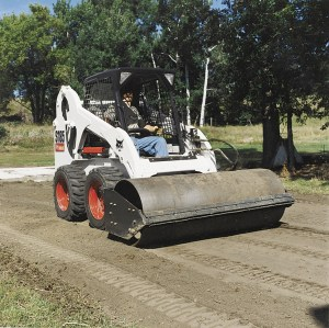 A vibratory roller attachment can be used for patch work and compaction of base material.