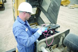This technician is taking a coolant sample from a radiator -- a very important part of any maintenance program.