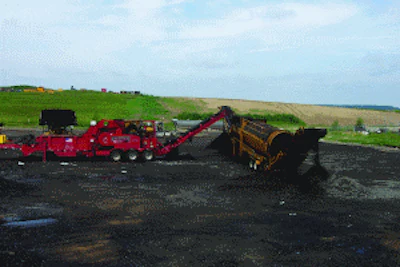 Mark Pahl with Dem-Con Shingle Processing uses a grinder designed specifically to process shingle material. The raw asphalt shingles are first ground to under a 1/2-inch minus size, and that material is then fed to a trommel to reduce the ground shingle material to an even finer size.