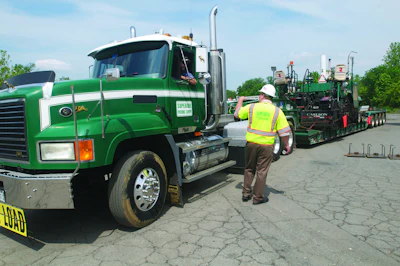 Superior Paving fleet manager Mike Blevin talks with a Superior Paving driver, who was hauling a low-boy trailer at the company's asphalt plant in Centreville, VA.