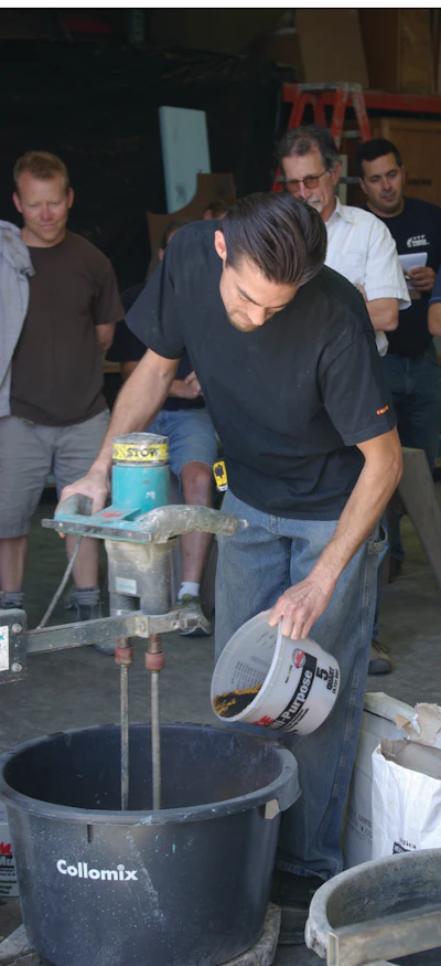 Students at Cheng Concrete add pigment, one of several common admixtures used in precast mixes, to the concrete mix.