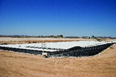 After a grading contractor spread and compacted the treated material on the sloped side walls, the entire pond was covered with a two-layer liner to seal it from any leakage.