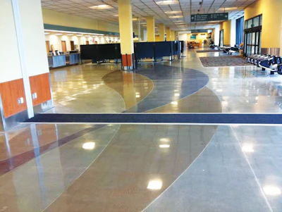 Two ribbons of color -- one black and one sepia -- wind throughout the floors of the Anchorage airport.