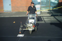 Nathan Witthuhn, owner of DMO Striping, is pictured completing striping work. DMO Striping offers services including crack fill, striping, sealcoating and infrared asphalt repair.