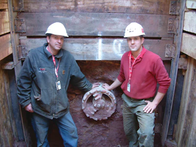 ICON Tunnel Systems' Rob Langenbach, operations manager and chief operator, and Dan Paster, national guided auger boring consultant and operator, stand in the receiving pit next to the Front Steer Boring Head.