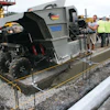The mid-size curb and gutter machine pours close to the 90-degree transition point.