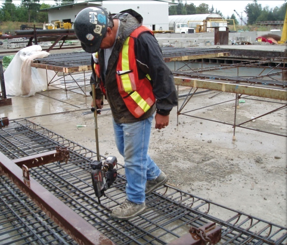 When tying rebar at ground level, using an extension handle on a powered rebar tying tool will help protect against back pain and injury.