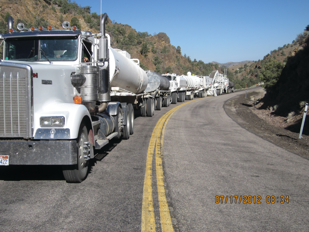 The mobile recycling train is led by a water truck towing a lime-slurry trailer. The next machine is a Roadtec RX-900 milling machine, which pulverizes the asphalt to a depth of 3 inches and conveys the material back to a Roadtec RT-500 mobile recycler.