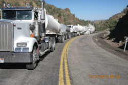 The mobile recycling train is led by a water truck towing a lime-slurry trailer. The next machine is a Roadtec RX-900 milling machine, which pulverizes the asphalt to a depth of 3 inches and conveys the material back to a Roadtec RT-500 mobile recycler.
