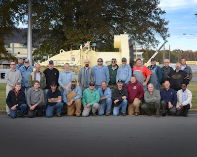 The Astec burner team gathers around the 500th burner built by Astec.