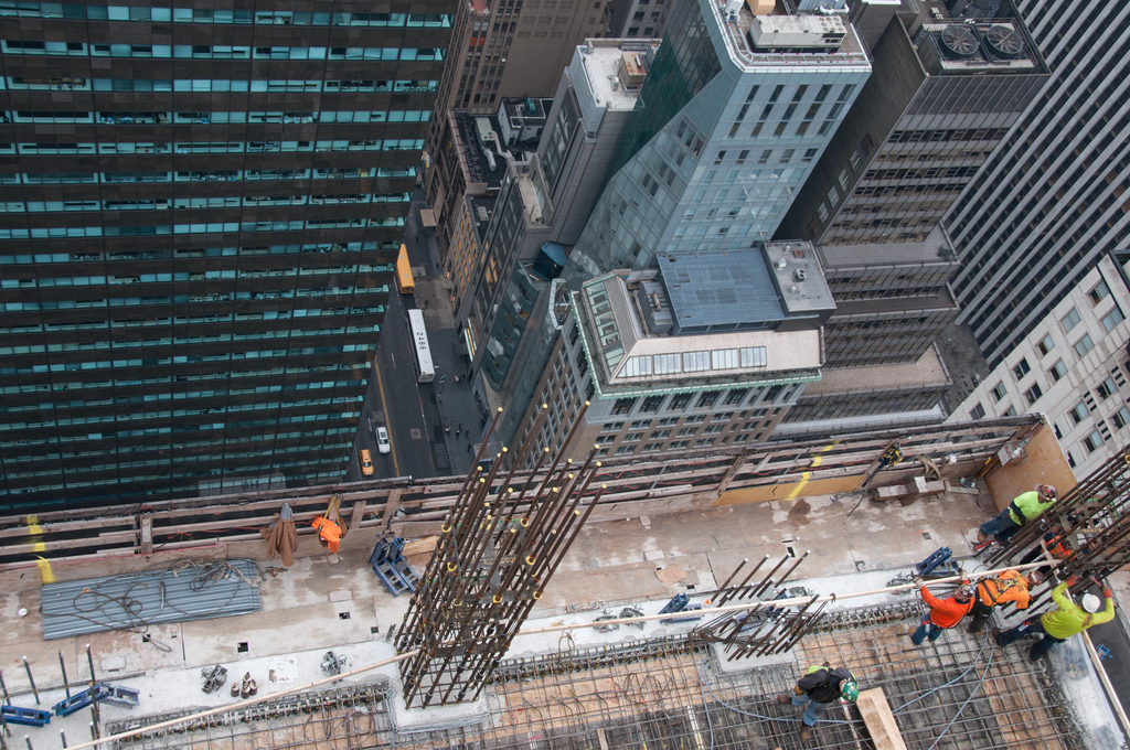 Looking down from above, workers use the top floor of the five story DOKA self-climbing deck system to erect column reinforcement.