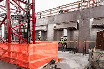 Stainless steel-hinge forms for the architectural column and spandrel beams are attached to the self-climbing scaffold system and move with the scaffold.