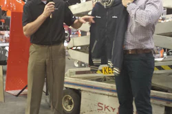 Matthew Kraner, co-owner of Kraner Electric Ltd. in Guelph, Ontario, Canada, is shown accepting a vintage jacket that commemorates the honor of owning the oldest working Skyjack scissor lift.