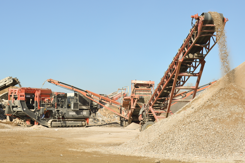 The Sandvik QI240 is a 43-ton crusher that moves on 20-inch-wide tracks and can be transported by trailer.