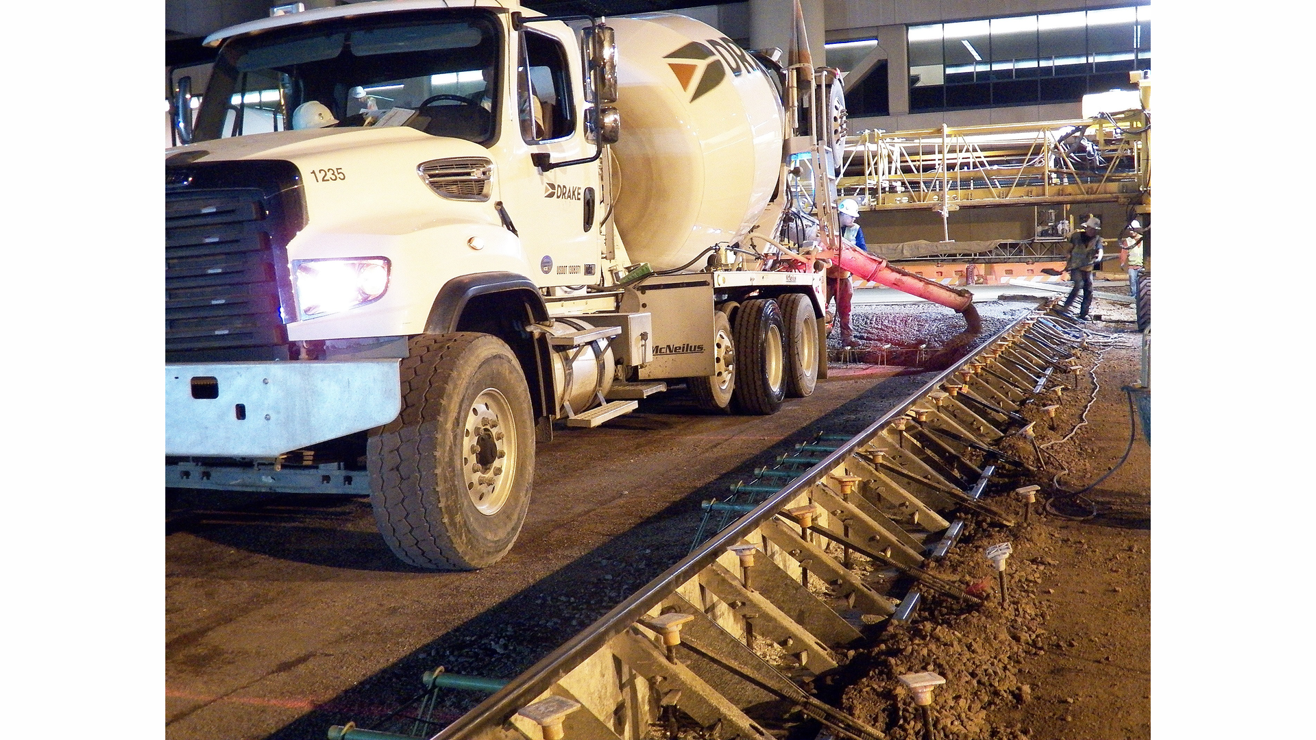 Transit mixers worked inside metal paving forms, sometimes hauling as many as 120 truckloads a night, to repave gate areas at Phoenix Sky Harbor International Airport.