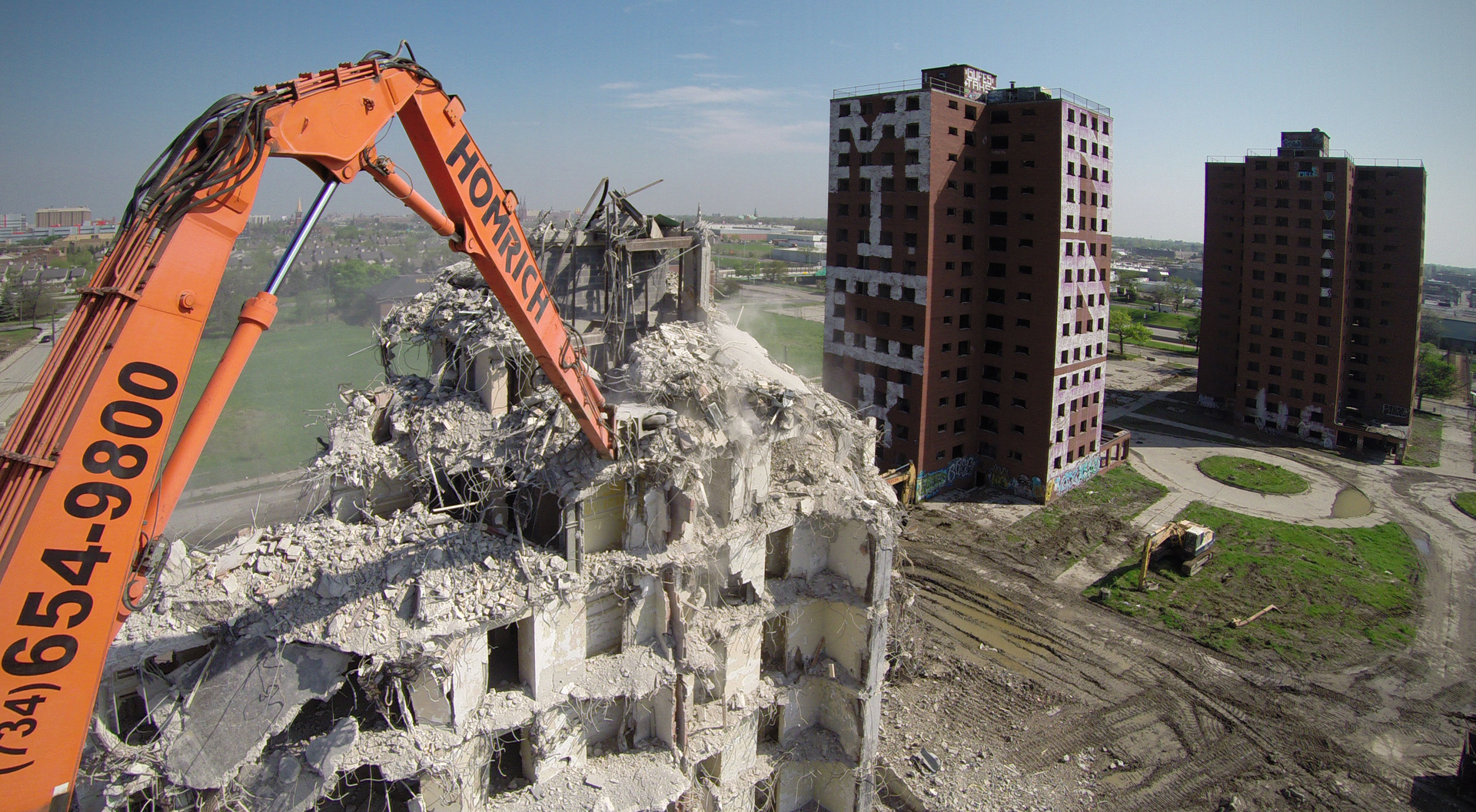 Contractor Homrich utilized its Hitachi 800 Ultra High Reach, in combination with an old-fashioned wrecking ball hung from a 200-ton truck crane to safely demolish four 15-story high-rise buildings.