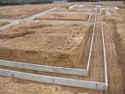 The overdig of this excavation combined with suspended footing forms provides protection from standing water in a confined space for this project.