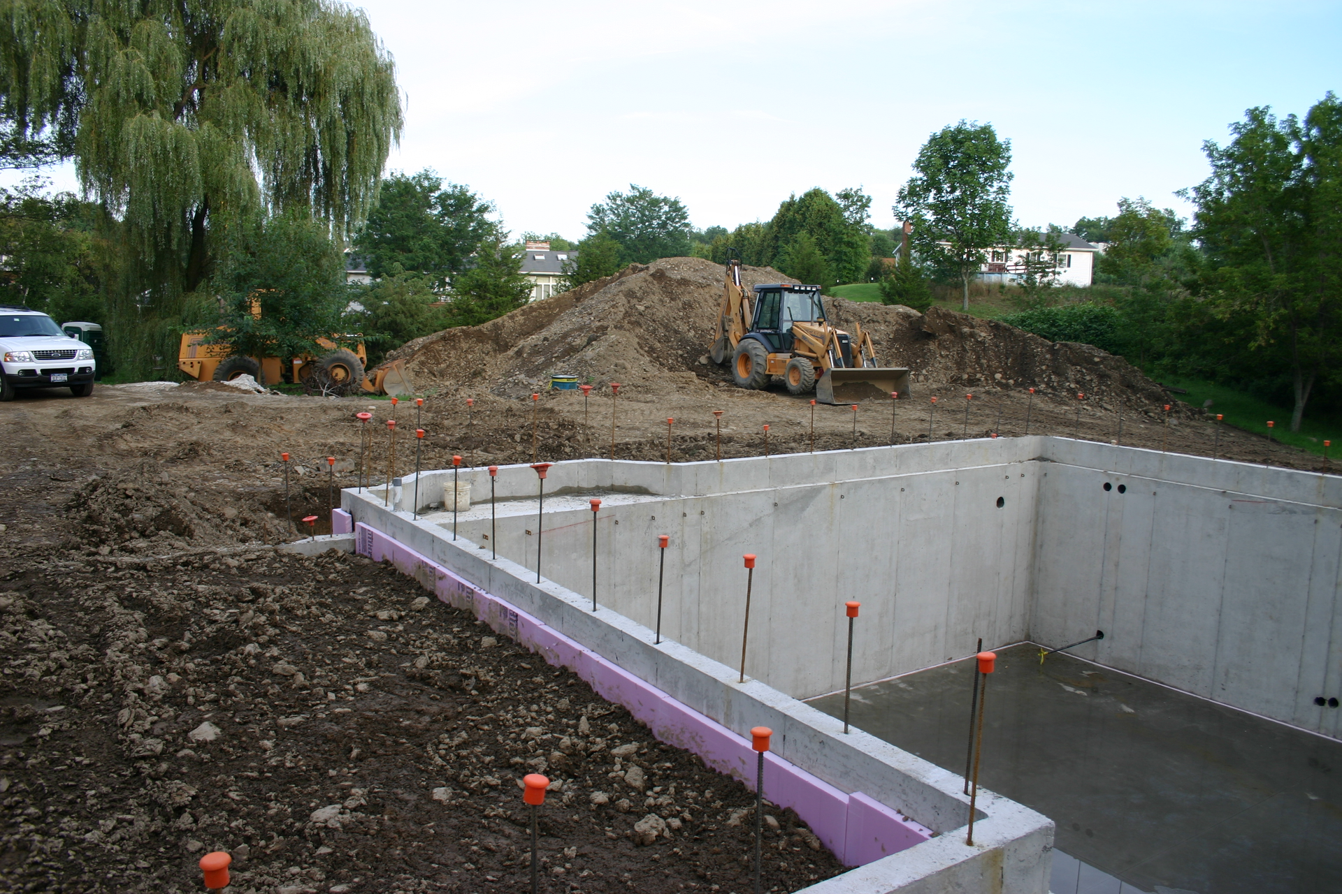 Pictured here is a foundation fully backfilled without a top connection in place. Short walls, corners, offsets and a yard wall provide stability for the backfill before the top connection is in place.