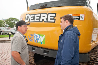 Chad Pregracke, left, of Living Lands & Waters and his new excavator, which will be put to work cleaning up the Ohio River.