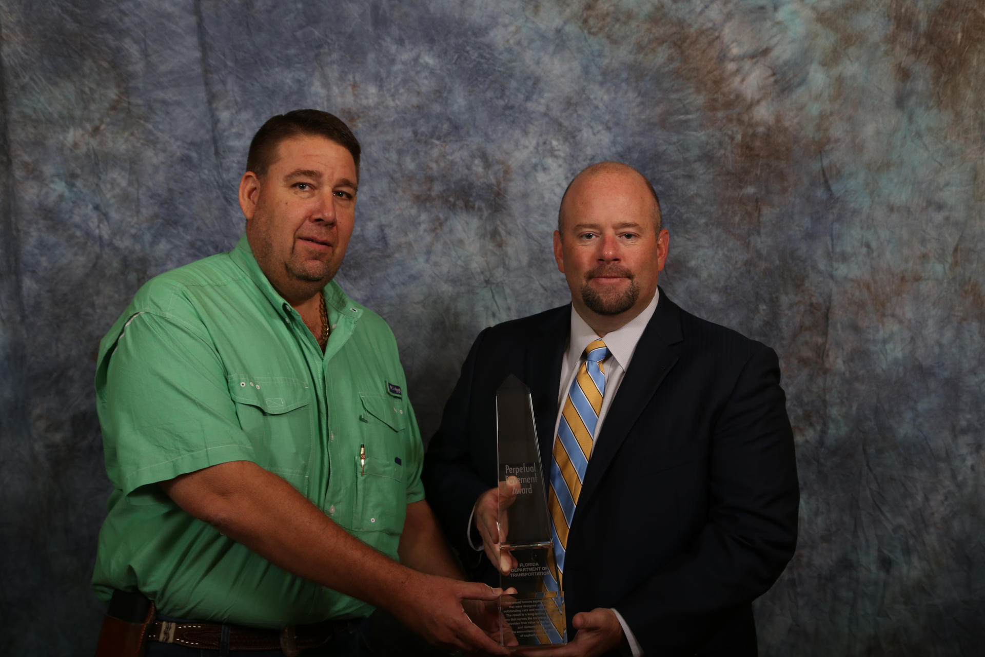 Kevin Wall, VP of Anderson Columbia and current Asphalt contractors Association of Florida (ACAF) President (green shirt) and Jim Boxold, FDOT Secretary of Transportation. The obelisk and plaque were awarded at the ACAF’s 40th Annual Asphalt Conference and Tradeshow in Orlando on 9-13-16.
