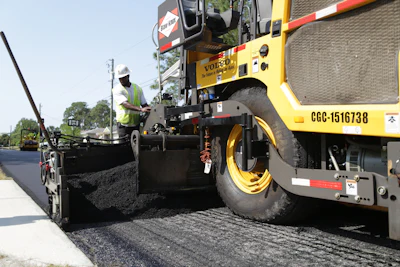Screed operators keep a close eye on the mat to retain consistency. The goal of the “coffee cup challenge” is for residents to be able to drive down the newly paved street with a cup of coffee and not spill a drop.