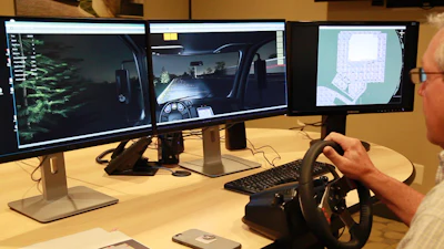 Mike Lucht, 1-800-SWEEPER president and founder, takes a 'test drive' on the organization's new training simulator. Note the trees out the left side view of the cab, the debris field immediately ahead of the sweeper, and the overhead view on the right-hand screen.