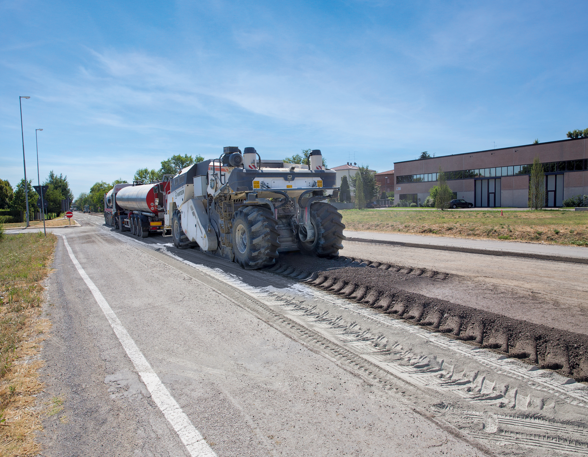 The entire damaged road surface and base course is reused. Once the Wirtgen WR 240/ WR 240i has processed the recycled material in-place, it is leveled by a motor grader and compacted with a roller. A paver subsequently lays down the new asphalt course.