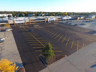 Initially the job was a mill and fill project. Asphalt Contractors had intended to just do a small patch but the inspector read the plans and determined the entire parking lot had to be milled, paved and striped before the stores could open.