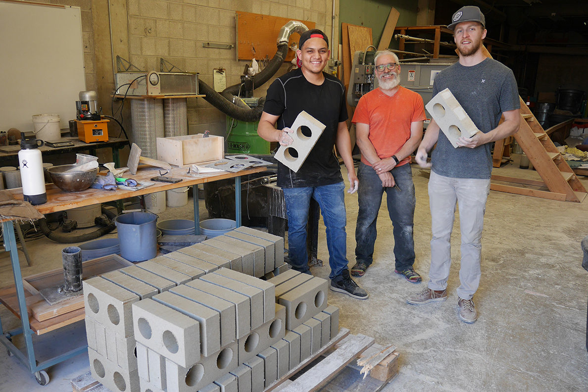 Washington State University team Jose Becerra, David Drake and Jacob Sauer (left to right) display brick they have made from drywall construction waste.