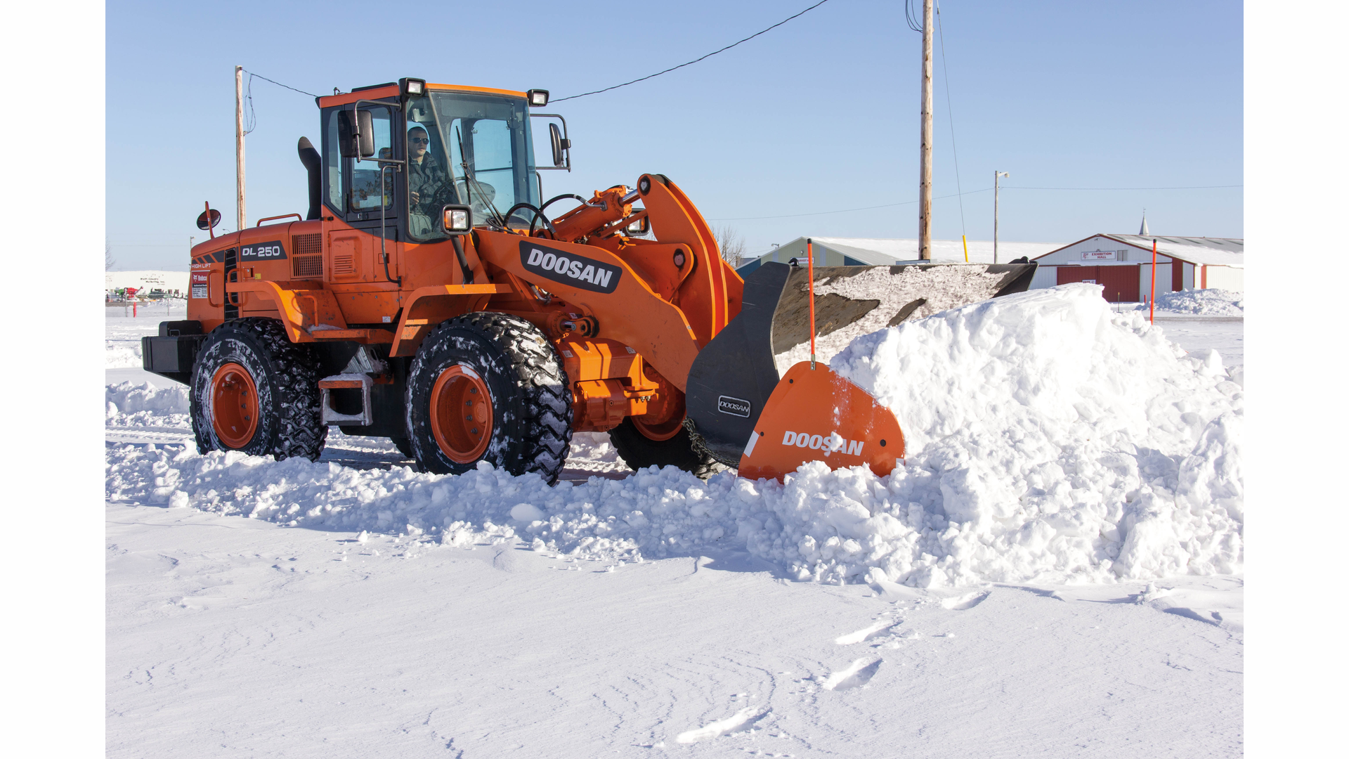Make sure snow pusher attachments interfacing with a bucket are properly secured prior to use.