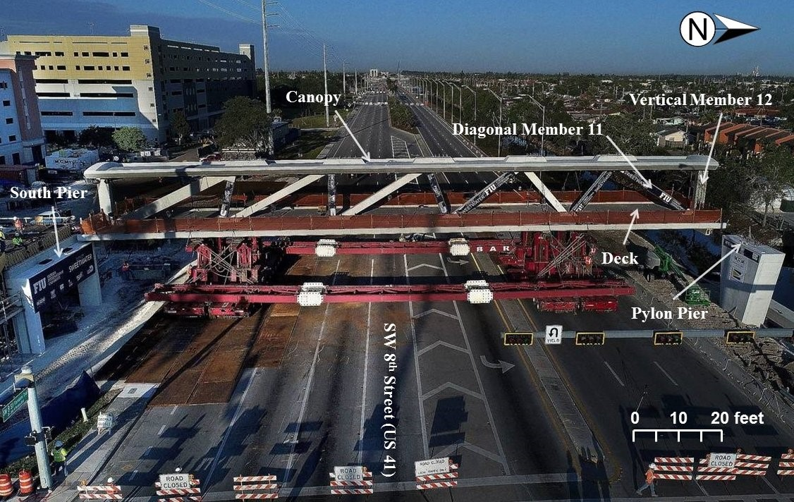 Photograph of 174-ft.-long main span on March 10, 2018, prior to placement on south pier and north pylon pier, looking west. Labels showing diagonal member 11 and vertical member 12 added by NTSB.