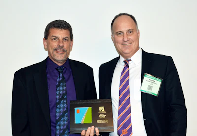 At FP2 board meeting Jan. 15, incoming president Scott Bergkamp, president, Bergkamp Inc. (left), offers token of appreciation to outgoing president Andrew Crow, vice president, pavement technologies, Ingevity
