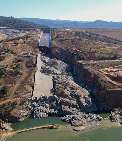 In February of 2017 the California Department of Water Resources opened the spillway on the Oroville Dam to reduce the flood water level of the lake. Rushing water destroyed the center portion of the spillway floor, washed away a section of the spillway wall, and created a 150 deep canyon in the spillway. With the dam at risk in the event of another flood an emergency construction project commenced to replace the spillway and the emergency spillway beside it. Photo Credit: DWR