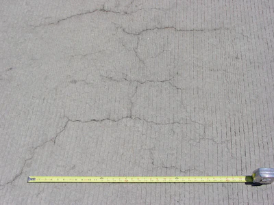 Occurring in both random and parallel patterns, plastic shrinkage cracks are discontinuous, relatively short and typically fairly shallow. Occasionally they can become full-depth cracks. Parallel cracks are typically spaced between a few inches to several feet apart and many times are oriented perpendicular to the prevailing wind direction. Cracks widths at the surface can be fairly wide (as much as 1/8 in.) but rapidly diminish with depth.