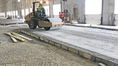 Base course being compacted with vibratory roller.