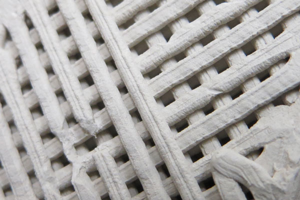 Prototype samples of 3D-printed concrete. The cube is about 1 square inch in volume.