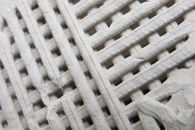 Prototype samples of 3D-printed concrete. The cube is about 1 square inch in volume.