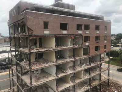 The demolition strategy was to first gut the building and remove the brick. Then, crews methodically torch cut the structural steel, leaving stickers. Then, they rigged the steel with softeners, straps, wire rope, and shackles and pulled the steel down section by section.
