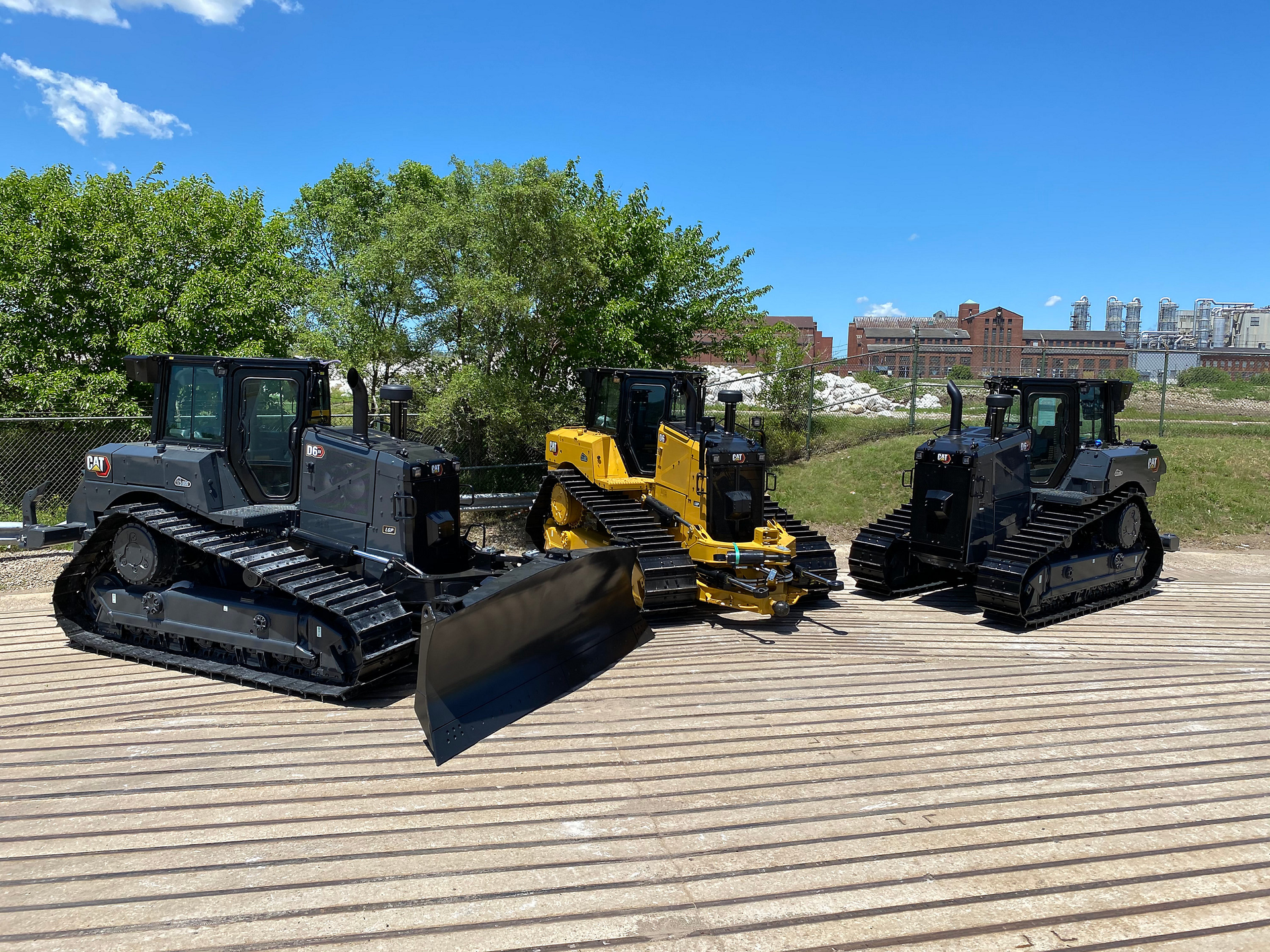 The first two commemorative units were D6 XE electric drive dozers, featuring a sleek dark gray and black paint scheme. The third commemorative unit is a D6 dozer finished in traditional Cat yellow with special black tracks and blade.
