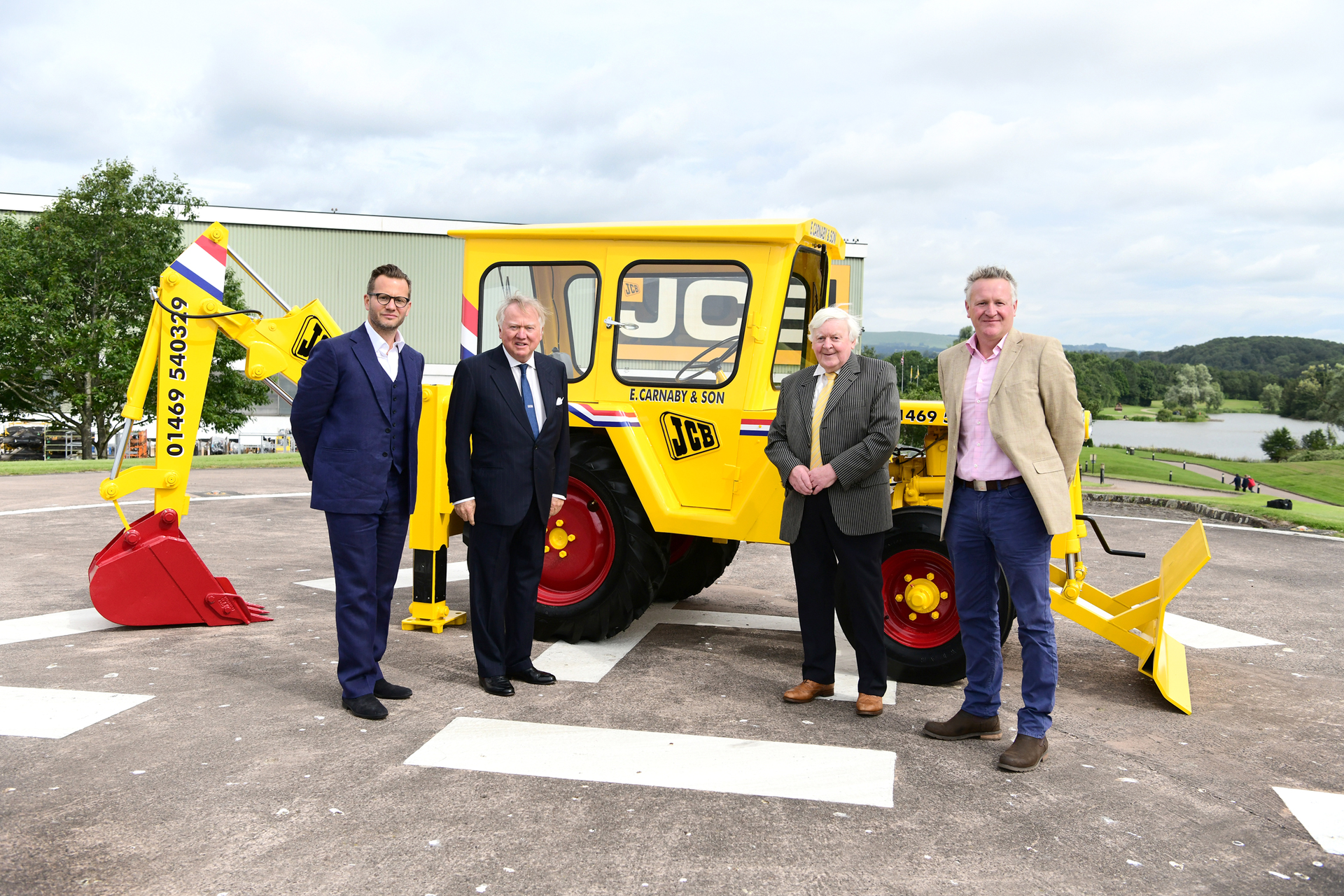 Shown with the restored 1964 JCB 1 backhoe (from left to right): George Bamford, Sir Anthony Bamford, Roland Carnaby Sr. and Roland Carnaby Jr.