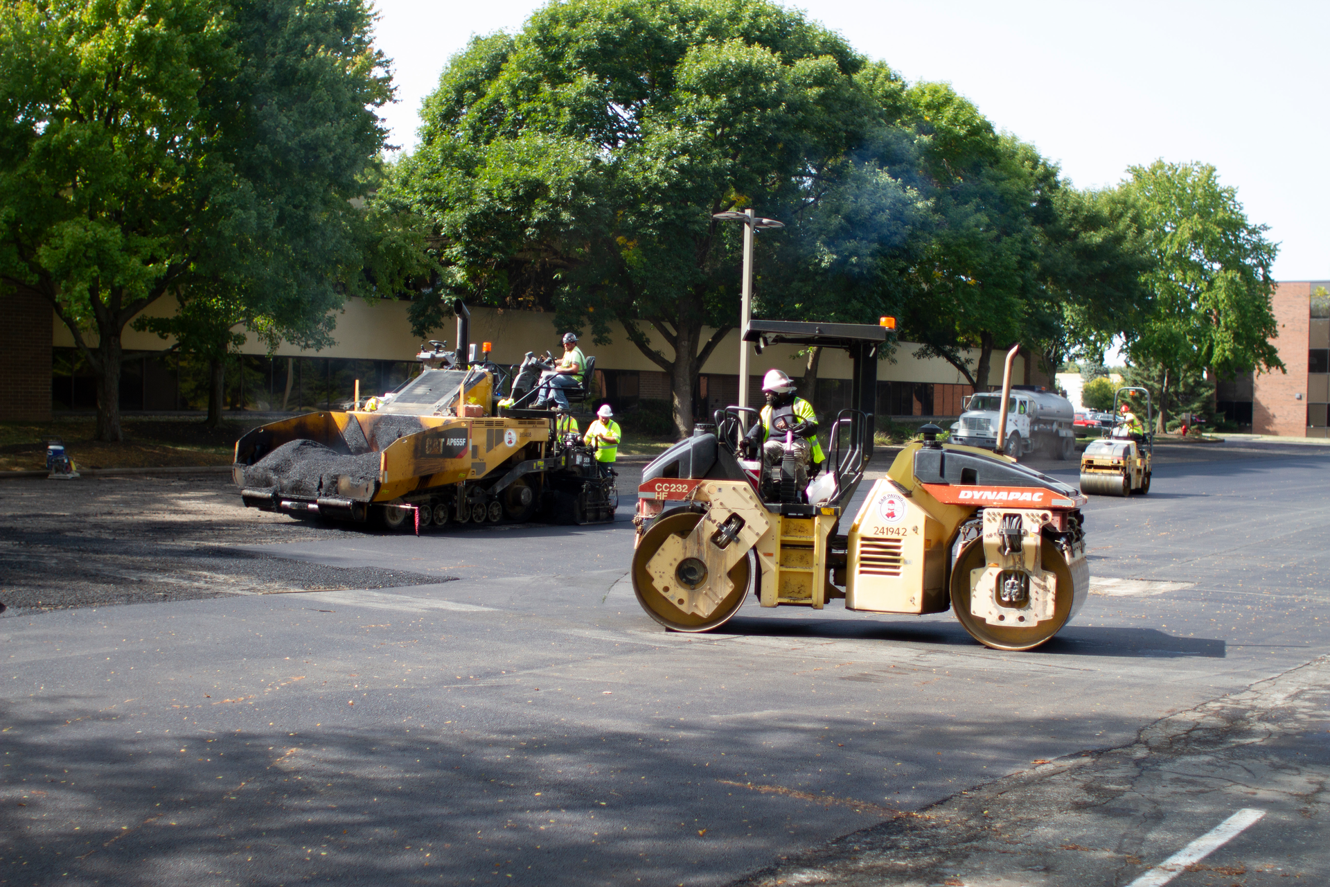 At the job site, the E&B Paving crew pours and rolls the RAP and Invigorate rejuvenator mixture, creating a smooth surface for the parking lot.