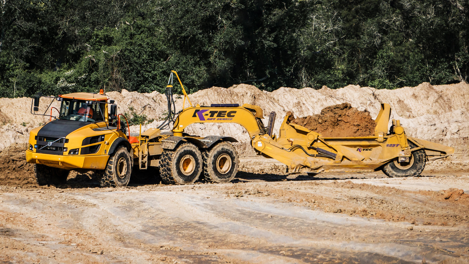Summit utilized two Volvo 40-ton articulated dump trucks pulling K-Tec 1237ADT scrapers (such as shown) in a train configuration on the long haul from the east spoil pile.