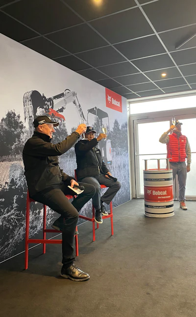 The Bobcat team, including Doosan Bobcat CEO Scott Park (center), raised glasses of prosecco to cheers the unveiling of Bobcat Company's new E19e excavator at a bauma 2022 press conference in Munich, Germany, on Monday, Oct. 24. Prost!