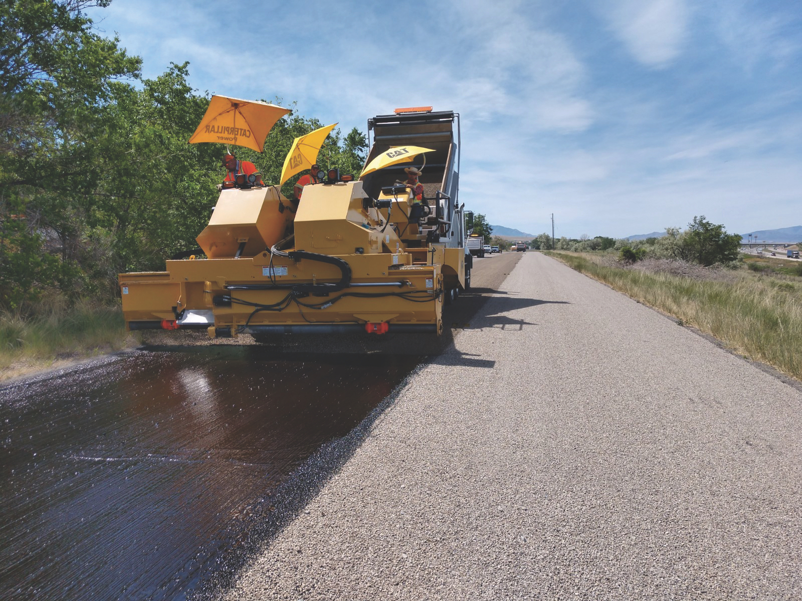 Crews place aggregate over oil emulsion