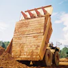Carryback works against efficiency by reducing payload in the haul truck as residual material is left sticking to the sides and bottom of the truck, decreasing hauling capacity for subsequent loads.