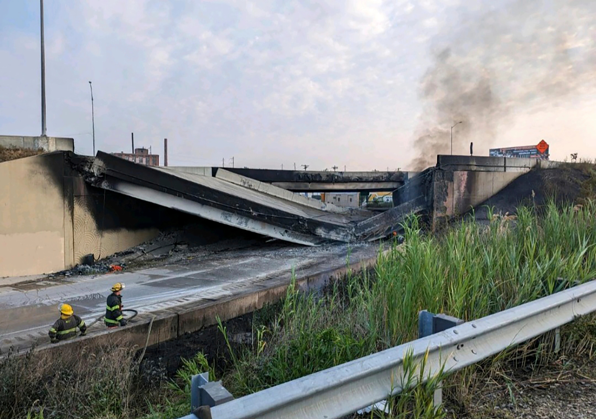 This image provided by the Office of Emergency Management shows firefighters standing near the collapsed part of I-95 in Philadelphia, Sunday, June 11, 2023.