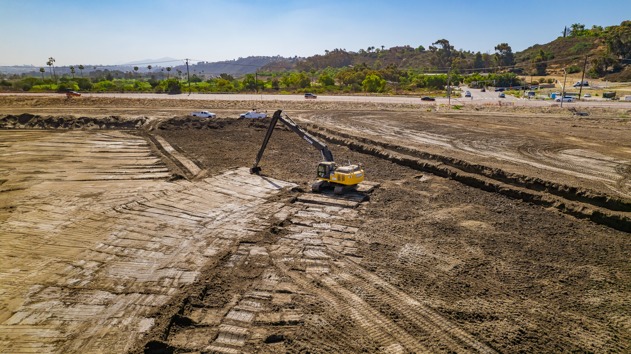 The operator uses an excavator with grade control to complete delicate earthmoving work at the San Dieguito Lagoon project.