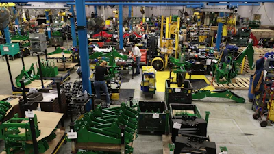 Amerequip's backhoe assembly before implementing 'The Toyota Way,' taken in 2021. Shows the congestion and inventory present within the backhoe assembly line.
