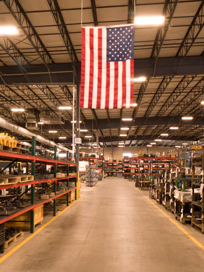 The Amerequip fabrication shop in 2021, prior to implementing 'The Toyota Way.' Shows the excessive amounts of inventory located throughout fabrication on pallet racking and stackable racks. Using the absorption metric as a driving KPI resulted in excess inventory rather than making only what is necessary.