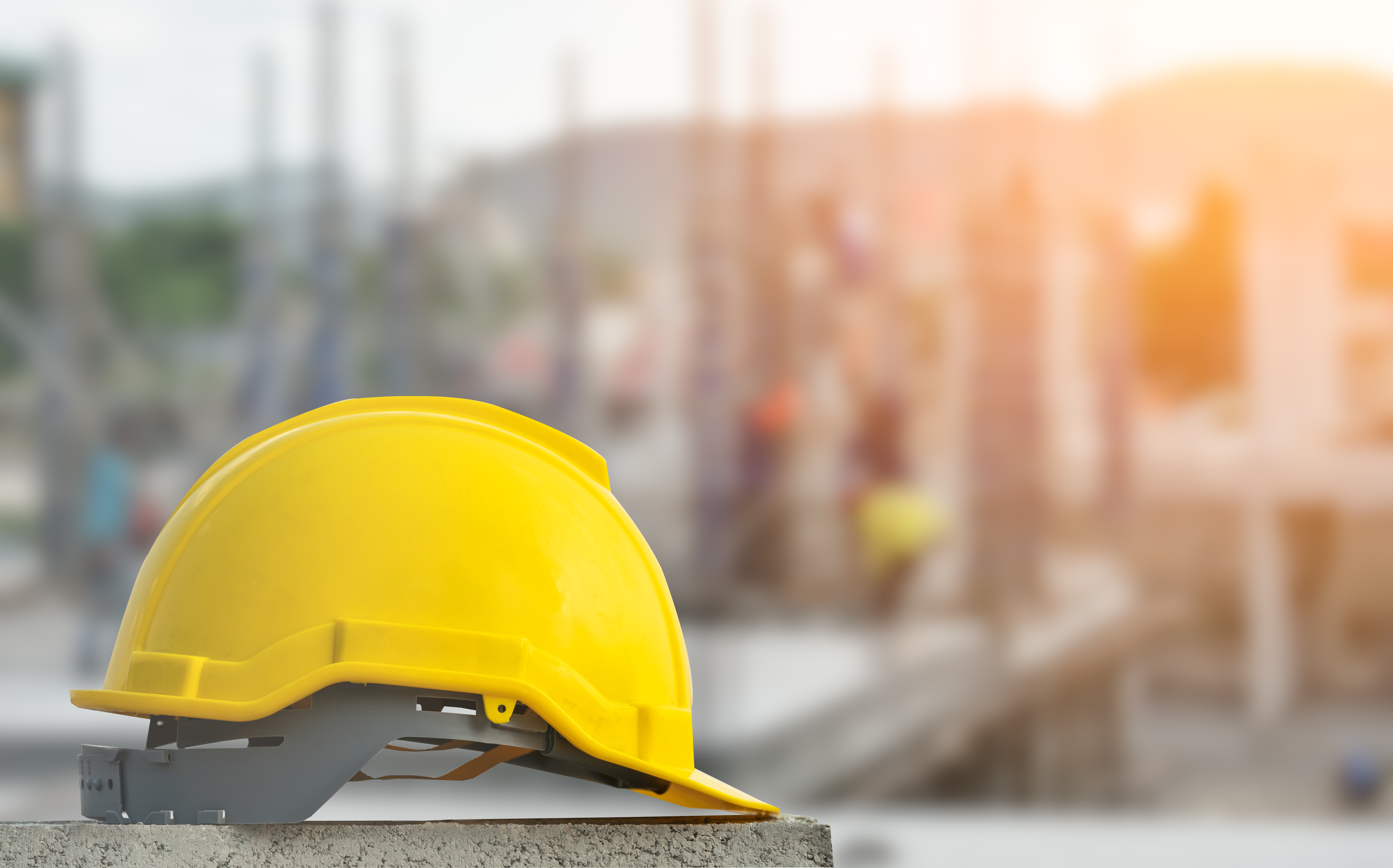 Yellow construction safety helmet on concrete at building site